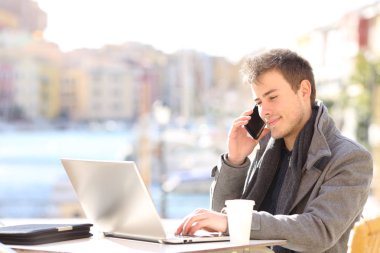 İşadamı bir kafede bir dizüstü online bilgilerini kontrol telefon sohbet