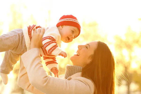 Backlighting Portrait Joyful Mother Raising Her Baby Outdoors Sunset Winter — Stock Photo, Image