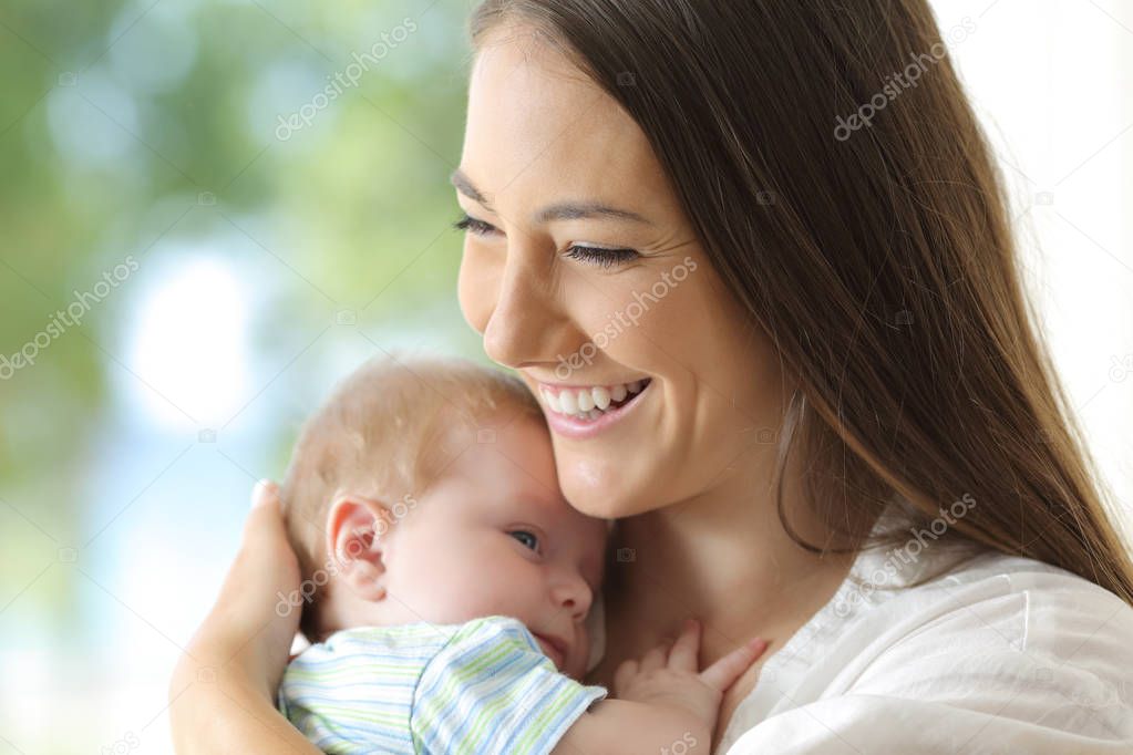 Portrait of a satisfied mother holding her baby at home