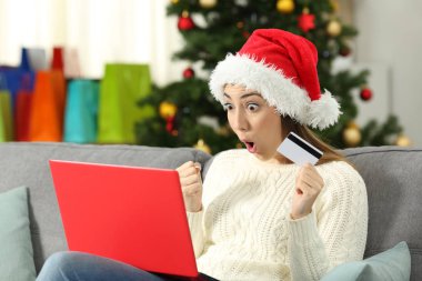 Oturma odasında evde bir kanepede oturan Noel hediye satırındaki alış kadın hayran