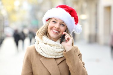 Mutlu kadın Noel içinde sokakta bakıyorsun telefon söz
