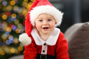 Noel Baba sana bir ağaç arka planda Noe de evde bir kanepede bakmak bebek kılığında