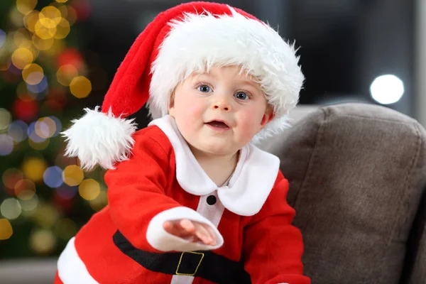 クリスマスに自宅のソファにサンタ クロースの衣装を着てかわいい赤ちゃん — ストック写真
