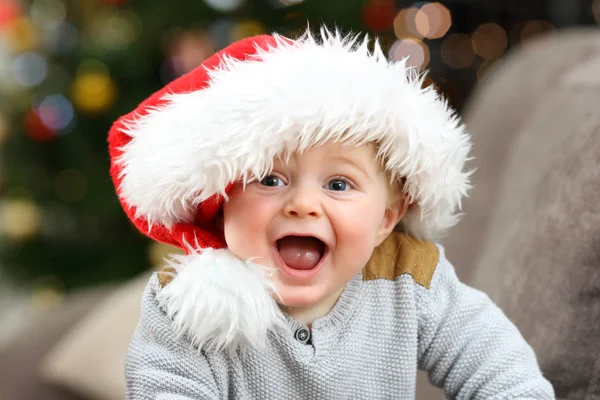 Возбужденный Ребенок Шляпе Санты Смотрит Тебя Рождество Диване Гостиной Дома — стоковое фото