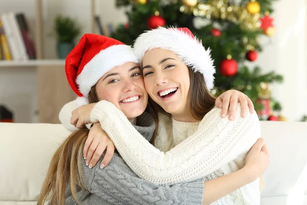 Amigos Abraçando Dia Natal Sentado Sofá Sala Estar Casa — Fotografia de Stock
