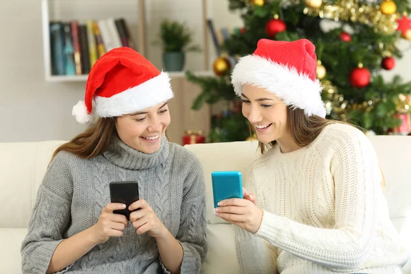 Двоє Друзів Діляться Вмістом Телефону Різдво Сидячи Дивані Вітальні Вдома — стокове фото
