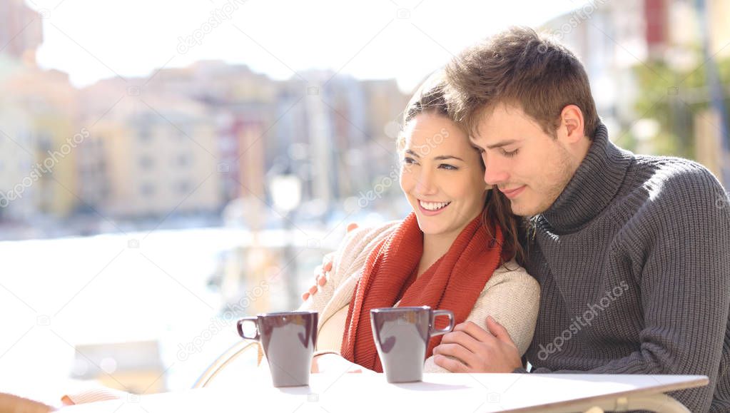 Romantic couple relaxing in a coffee shop in a coast town