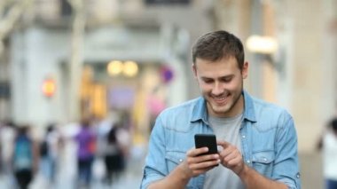 Yürüyüş ve sokağın ortasında bir akıllı telefon kullanan bir insanın önden görünüm