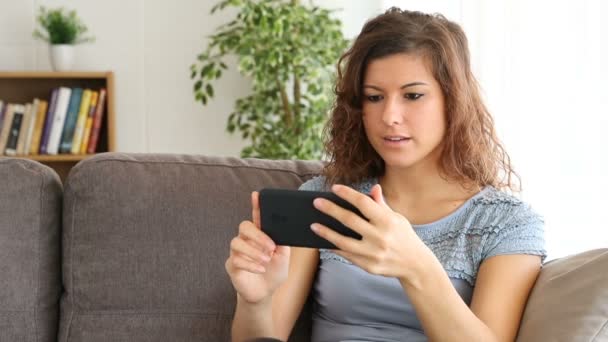 Chica Feliz Viendo Contenido Multimedia Teléfono Inteligente Después Elegirlo Sentado — Vídeos de Stock