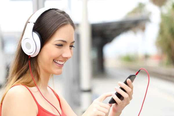 Счастливая Женщина Слушает Выбирает Музыку Смартфоне Наушниках Вокзале — стоковое фото