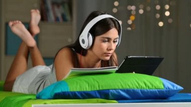 Gece evde bir yatakta yatarken bir tablet ve defter notları karşılaştırarak genç e-öğrenme
