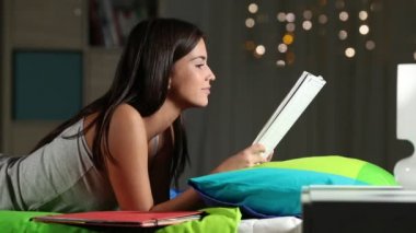 Yan görünümü gönüllülük bir defter bir yatakta evde gece okuyan bir genç portresi