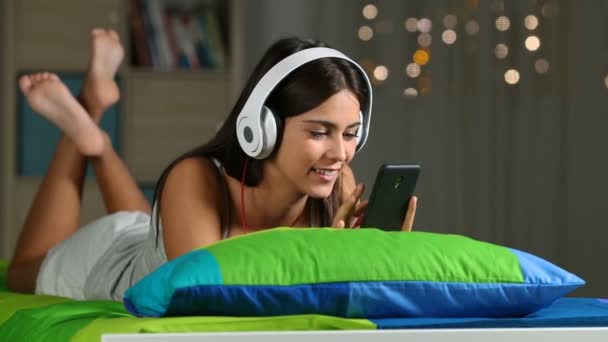 Adolescente Ouvindo Música Com Telefone Fones Ouvido Casa Sentado Sofá — Vídeo de Stock