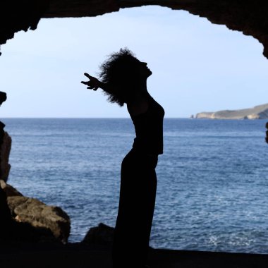 Yan görünüm portre sahilde bir mağaranın içine nefes bir mutlu bir kadın silueti