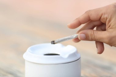 Sigara Sigara kül tablası atma yapılan bir ele sahip bir kadının yakın çekim