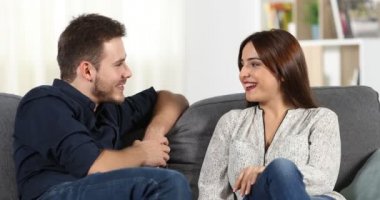 Mutlu çift tanışma ve evde bir kanepede oturan konuşurken flört