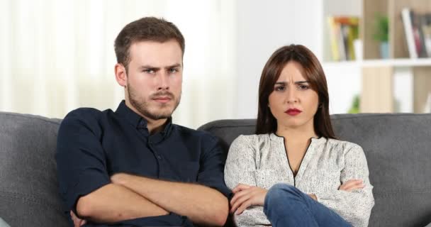前视图的愤怒的夫妇看着相机坐在沙发上在家 — 图库视频影像