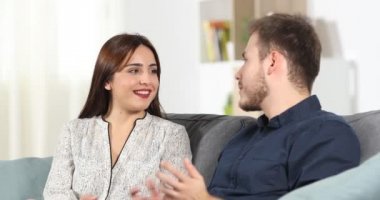 Couple dating talking sitting on a couch at home