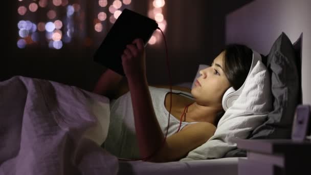 Menina Séria Assistindo Mídia Tablet Fones Ouvido Deitados Cama Durante — Vídeo de Stock