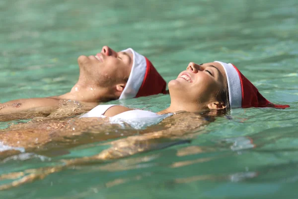 Casal Feliz Vestindo Chapéus Papai Noel Flutuando Uma Praia Tropical — Fotografia de Stock