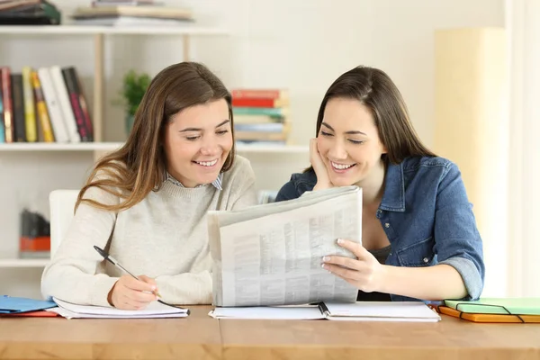 两个快乐的学生在家里谈论报纸新闻 — 图库照片