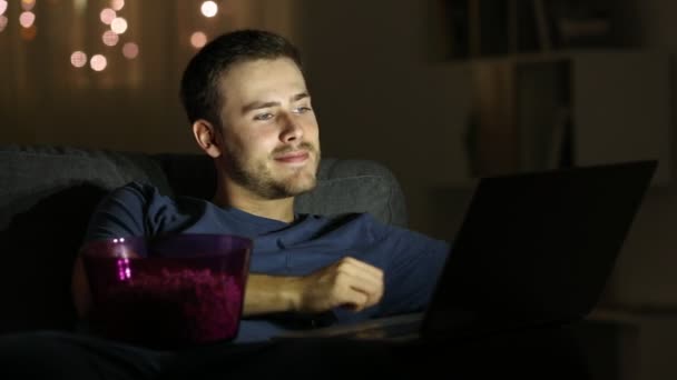 Homem Feliz Assistindo Laptop Comendo Pipocas Sentado Sofá Noite Casa — Vídeo de Stock