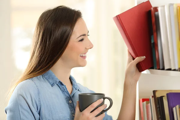 Mulher Feliz Escolhendo Livro Uma Prateleira Casa — Fotografia de Stock