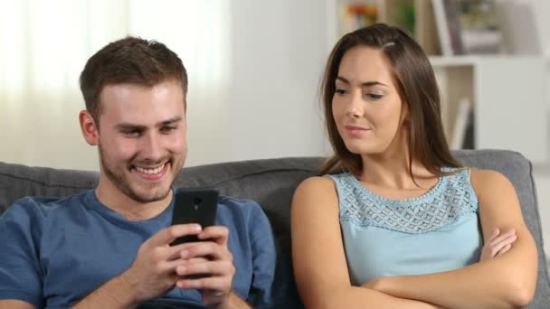 嫉妒的妻子骂她的丈夫谁是在家里使用智能手机 — 图库视频影像