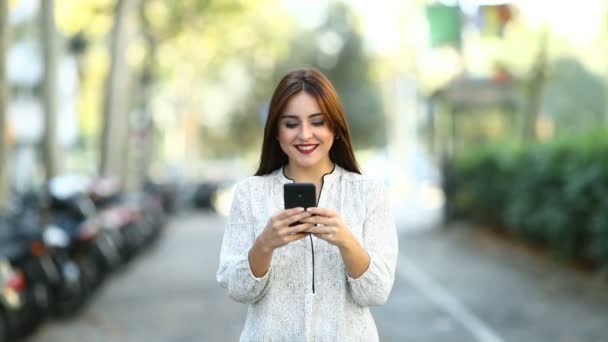 Vista Frontal Una Mujer Feliz Caminando Usando Teléfono Inteligente Calle — Vídeo de stock