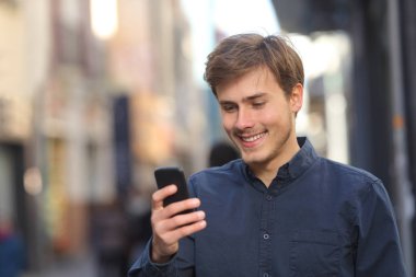 Mutlu adam eski bir şehir sokakta yürürken akıllı telefon içerik denetimi