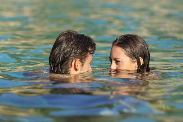 幸せなカップルが休暇でビーチに透明な水でいちゃつく入浴をヘッドします — ストック写真