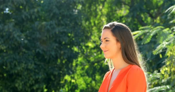 在一个有绿色背景的公园里 橙色的快乐女人呼吸着深深的新鲜空气 — 图库视频影像