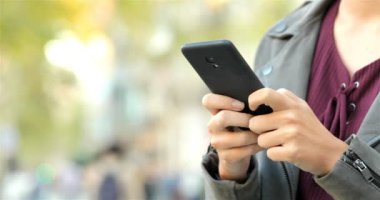 Bir kadın el manifatura bir akıllı telefon sokakta, yakın çekim