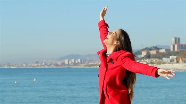 一个快乐的女人在冬天在海滩上享受阳光明媚的日子的缓慢动作 — 图库视频影像