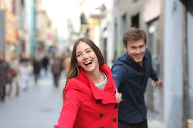 Mutlu çift birlikte sokakta kameraya doğru kışın çalışan