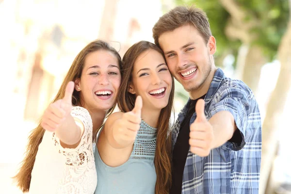 三个快乐的朋友在街上竖起大拇指微笑的正面画像 — 图库照片