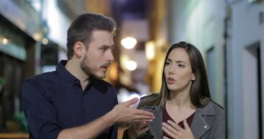 Kızgın bir çift sokakta kameraya doğru yürüyüş gecede savunarak önden görünümü