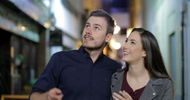 夜の街で観光をカメラに向かって歩いて幸せなカップルの正面図 — ストック動画