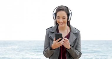 Tarama ve sahilde müzik dinlerken mutlu bir kadın önden görünümü
