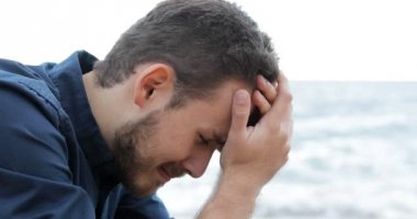 Sahilde ağlayan üzgün bir adam portresi