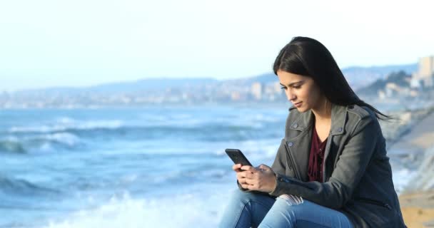 Gelukkig Tienermeisje Texting Slimme Telefoon Zittend Het Strand — Stockvideo