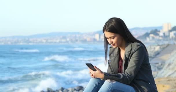 Chockade Tonårig Flicka Läsa Bra Online Nyheter Smart Telefon Stranden — Stockvideo