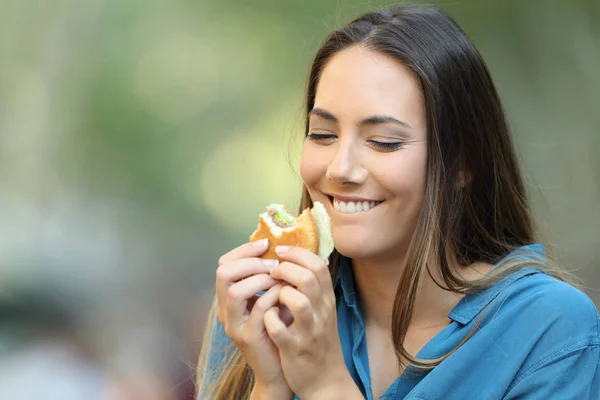 Lycklig Kvinna Äter Och Ser Läcker Hamburgare Gatan — Stockfoto