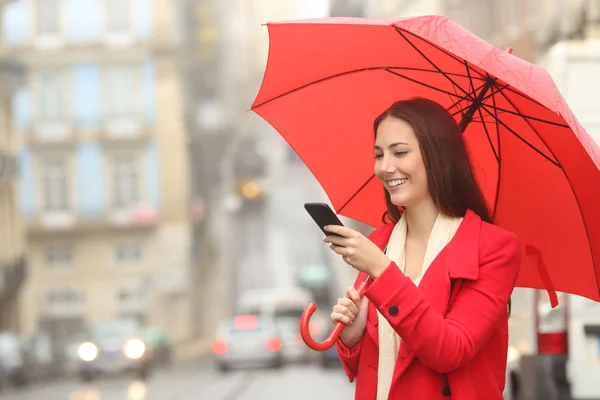 Donna Felice Rosso Utilizzando Uno Smartphone Sotto Pioggia Inverno Strada — Foto Stock