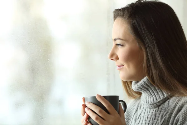 Mujer Feliz Mirando Lluvia Sosteniendo Café Través Ventana Del Hogar —  Fotos de Stock