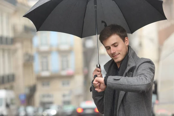 Hombre Comprobando Smartwatch Bajo Lluvia Caminando Calle Invierno — Foto de Stock