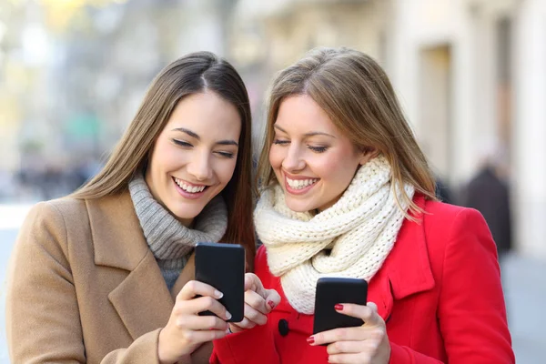 Vänner Som Konsulterar Innehåll Smarta Telefoner Gatan Vintern — Stockfoto