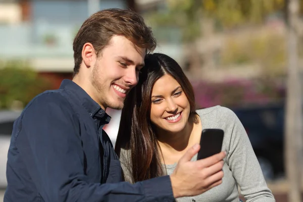 Pareja Feliz Consultando Contenido Del Teléfono Inteligente Sentado Banco Parque — Foto de Stock