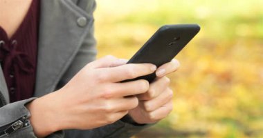 Bir kadın el manifatura bir parkta akıllı telefon yakın çekim