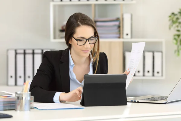 Trabajador Oficina Que Usa Anteojos Comparando Informe Con Contenido Tableta —  Fotos de Stock